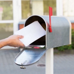 person putting envelope in mailbox