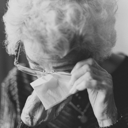 elderly woman wiping tears