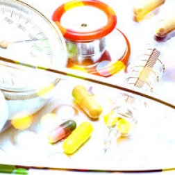 Pills, stethoscope, and syringe laid out on a table
