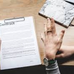man and womens hands next to a written contract