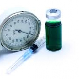 Syringe next to a vial and a stethoscope dial